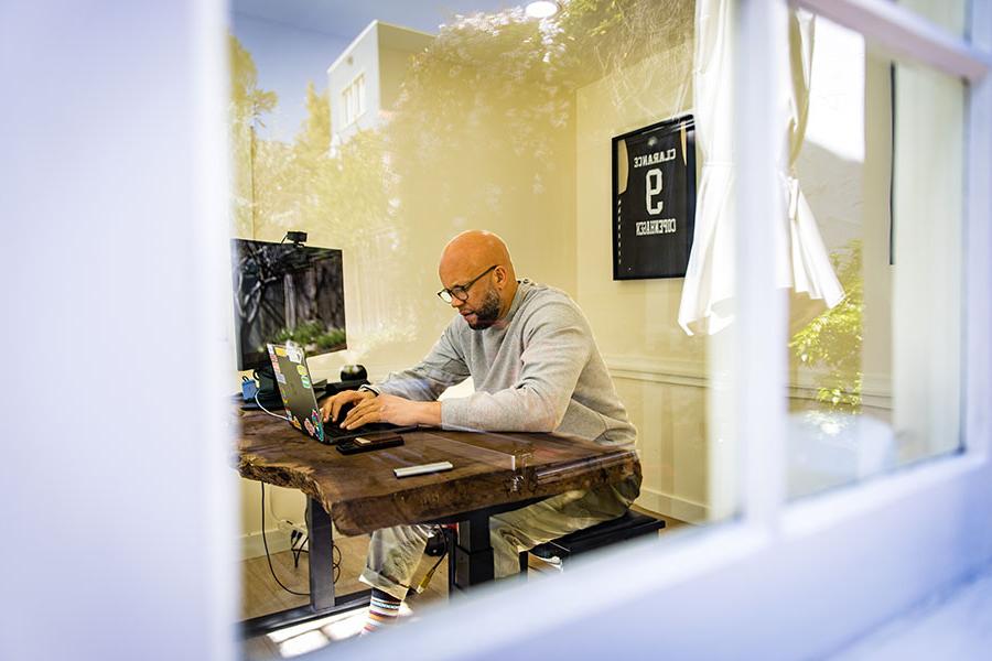 Bilal Clarance spends time working in his home office, where jerseys from his playing days in Denmark hang on the wall.